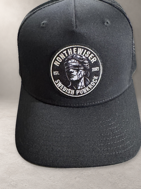 Nonthewiser Trucker High, svart keps på grå stenyta, framifrån
