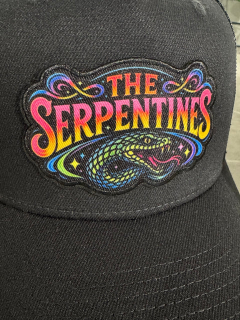 Närbild av The Serpentines Neon Snake-patch med färgstark text och ormhuvud på svart truckerkeps